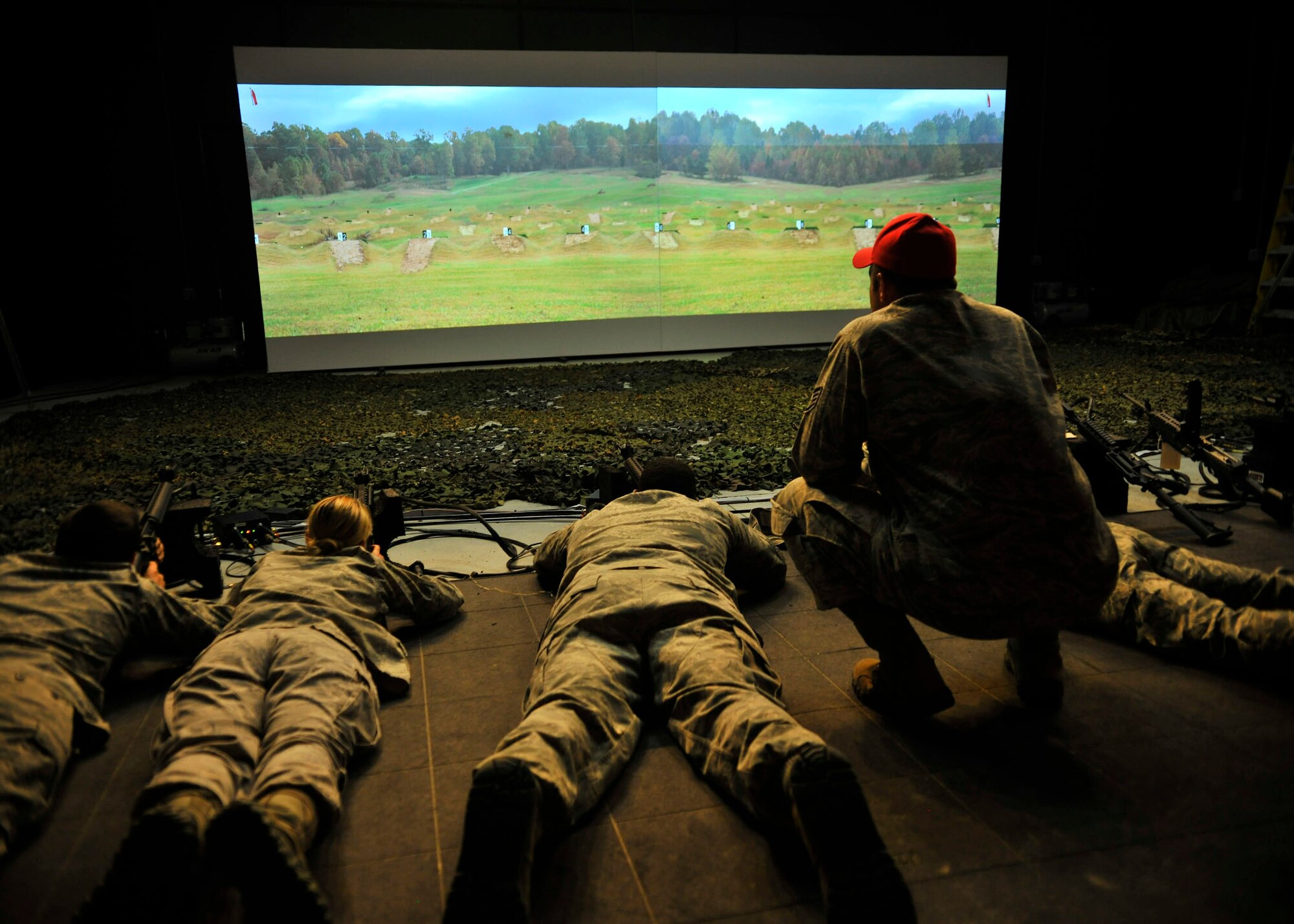U.S. Air Force Staff Sgt. Greg Chmielewski, 354th Security Forces Squadron combat arms instructor, offers shooting advice while using the engagement skills trainer at the Combat Arms Training Range July 9, 2013, Eielson Air Force Base, Alaska. An engagement skills trainer is a computer based training module which uses air compression and a surround sound system coupled with specially designed weapons to produce a shooting experience almost as good as the real thing. (U.S. Air Force photo by Senior Airman Shawn Nickel/Released)