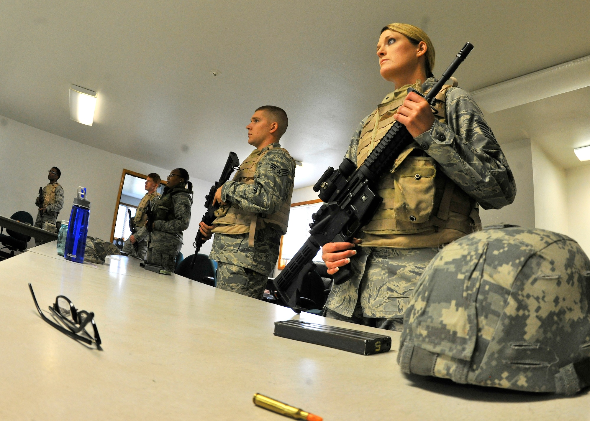 Airmen listen to instruction on how to fire an M-4 Carbine at the Combat Arms Training Range July 9, 2013, Eielson Air Force Base, Alaska. After completing classroom training, Airmen have the opportunity to hone their shooting skills using an engagement skills trainer. (U.S. Air Force photo by Senior Airman Shawn Nickel/Released)