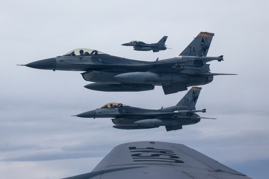 Three F-16 Fighting Falcons from the 132nd Fighter Wing, Des Moines, Iowa, are seen flying alongside the wingtip of a KC-135 Stratotanker from the 185th Air Refueling Wing, Sioux City, Iowa, during a refueling mission on June 21, 2013.  (U.S. Air National Guard photo by Senior Airman Dustin M. Smart/Released)