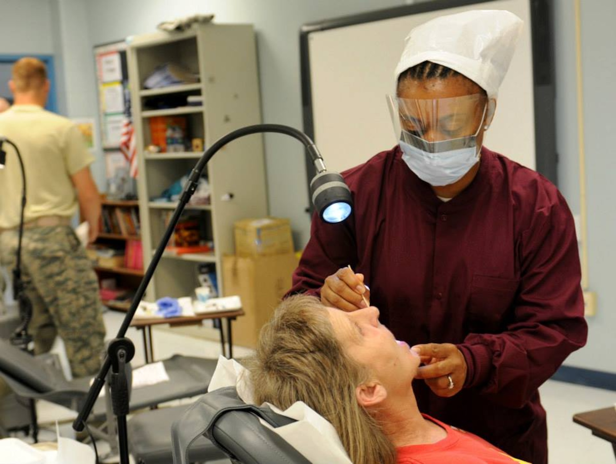 Air Force Maj. Tiffany Harper, a dentist with the 192nd Fighter Wing, Joint Base Langley-Eustis, Va. performs a cleaning June 10, 2013 at ‘Hope of Martin’ Innovative Readiness Training held at Martin Middle School in Martin, Tenn. (Air Force Photo by Tech. Sgt. Meghan Skrepenski, Virginia Air National Guard Public Affairs)