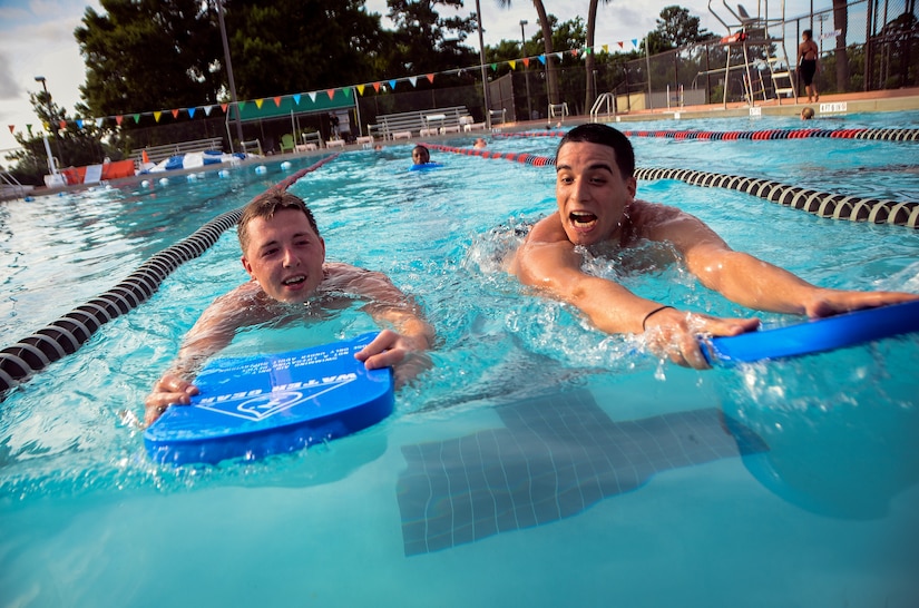 Senior Airman Robert Fortin, 628th Comptroller Squadron separation and retirement technician, and Airman 1st Class Lazaro Lazabal, 628th Comptroller Squadron customer service technician, race on kickboards during a physical training session July 10, 2013, in the pool at Joint Base Charleston – Air Base, S.C.  More than 20 Airmen from the 628th CPTS split into groups and accomplished three workout stations before finishing the PT session with aquatic exercises at the JB Charleston – AB pool. (U.S. Air Force photo / Senior Airman Jared Trimarchi)