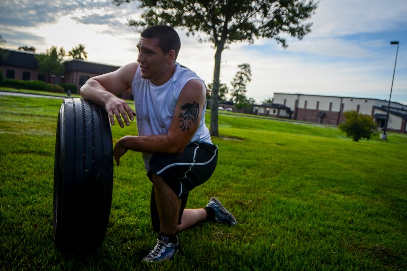 Airman 1st Class Destin Betsill, 628th Comptroller Squadron customer service technician, recovers after running with a truck tire during a physical training session July 10, 2013, at the Joint Base Charleston – Air Base, S.C.  More than 20 Airmen from the 628th CPTS split into groups and accomplished three workout stations before finishing the PT session with aquatic exercises at the JB Charleston – AB pool. (U.S. Air Force photo / Senior Airman Jared Trimarchi)