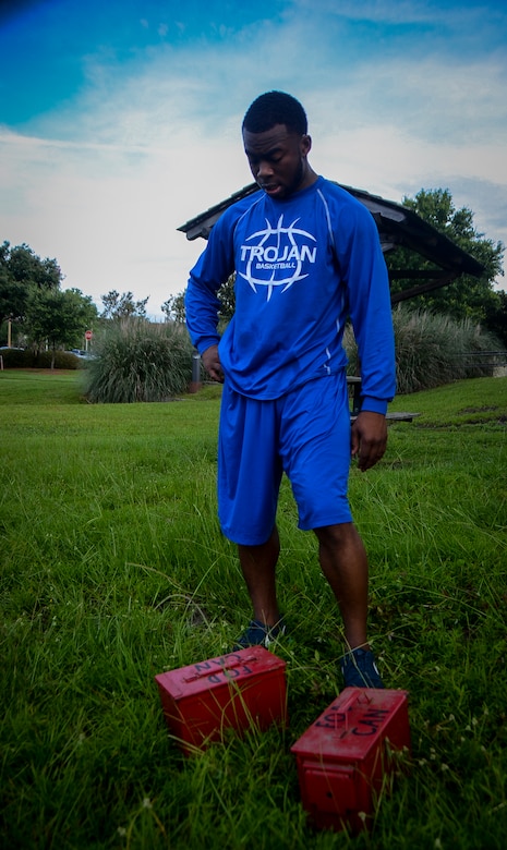 Airman 1st Class Xavier Miles, 628th Comptroller Squadron, recovers after doing squats with weighted ammo cans during a physical training session July 10, 2013, at Joint Base Charleston – Air Base, S.C.  More than 20 Airmen from the 628th CPTS split into groups and accomplished three workout stations before finishing the PT session with aquatic exercises at the JB Charleston – AB pool. (U.S. Air Force photo / Senior Airman Jared Trimarchi)