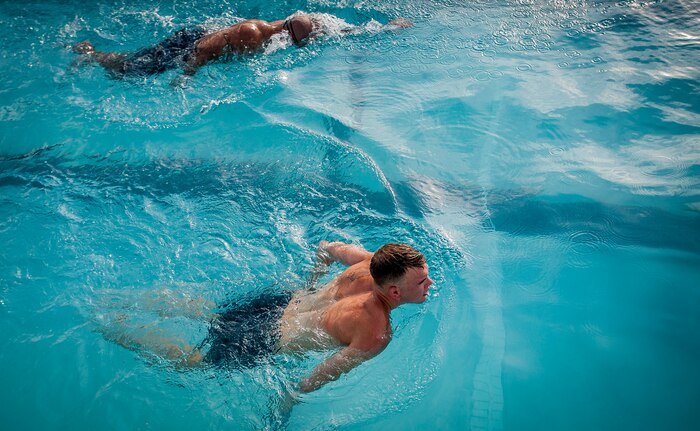 Senior Master Sgt. Benjamin Manalastas, 628th Comptroller Squadron superintendent,  and Airman 1st Class Dustin Davis, 628th Comptroller Squadron customer service technician, swim laps in the pool at Joint Base Charleston – Air Base, S.C.  More than 20 Airmen from the 628th Comptroller Squadron split into groups and accomplished three workout stations before finishing the PT session with aquatic exercises in the JB Charleston – Air Base Pool. (U.S. Air Force photo / Airman 1st Class Tom Brading)