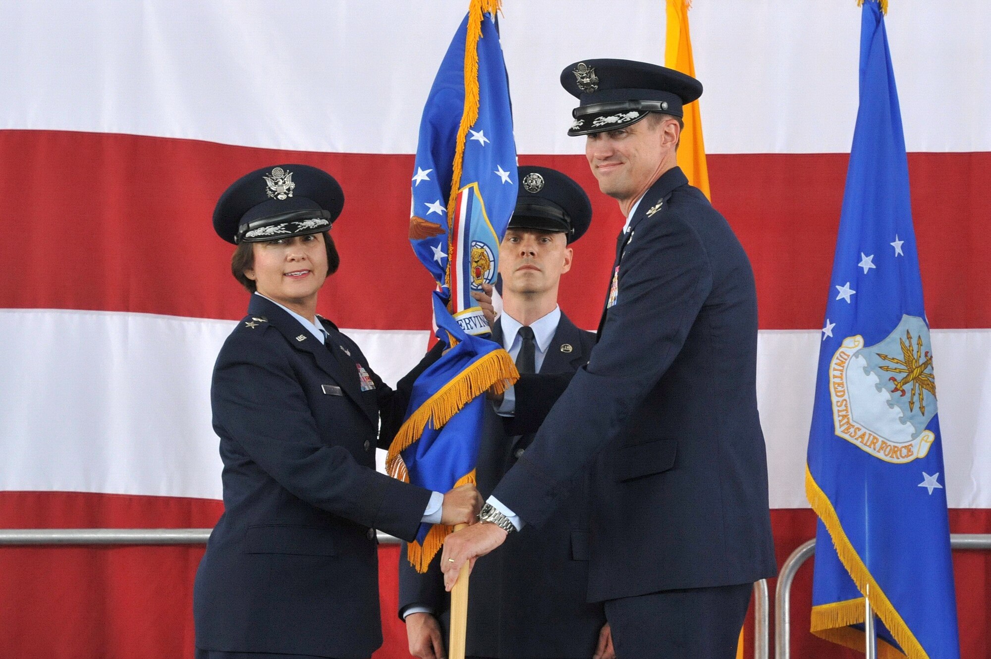 Maj. Gen. Sandra Finan, Air Force Nuclear Weapons Center commander, passes the guidon to Col. Tom Miller, new 377th Air Base Wing and installation commander, at a change of command ceremony July 11. Most recently, Miller served as the deputy commander for maintenance at the Ogden Air Logistics Complex at Hill Air Force Base, Utah. Miller succeeds Col. John Kubinec, who will move to Tinker AFB, Okla., to become the vice commander of the Air Force Sustainment Center.   (Photo by Ken Moore)