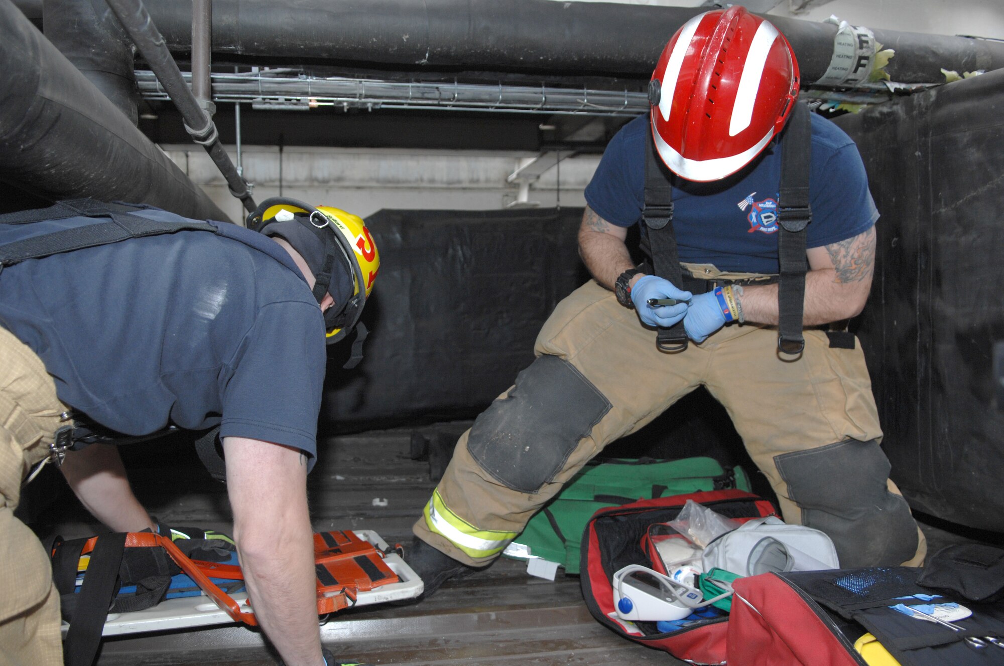 Firefighters from the 100th Civil Engineer Squadron Fire Department prepare to extract a simulated casualty during confined-space-rescue training July 2, 2013, in building 809 on RAF Mildenhall, England. The training required firefighters to have situational awareness in order to safely extract the casualty. Confined-space-rescue training is an annual requirement, but the RAF Mildenhall firefighters perform it two-to three-times a year. (U.S. Air Force photo by Airman 1st Class Dillon Johnston/Released)