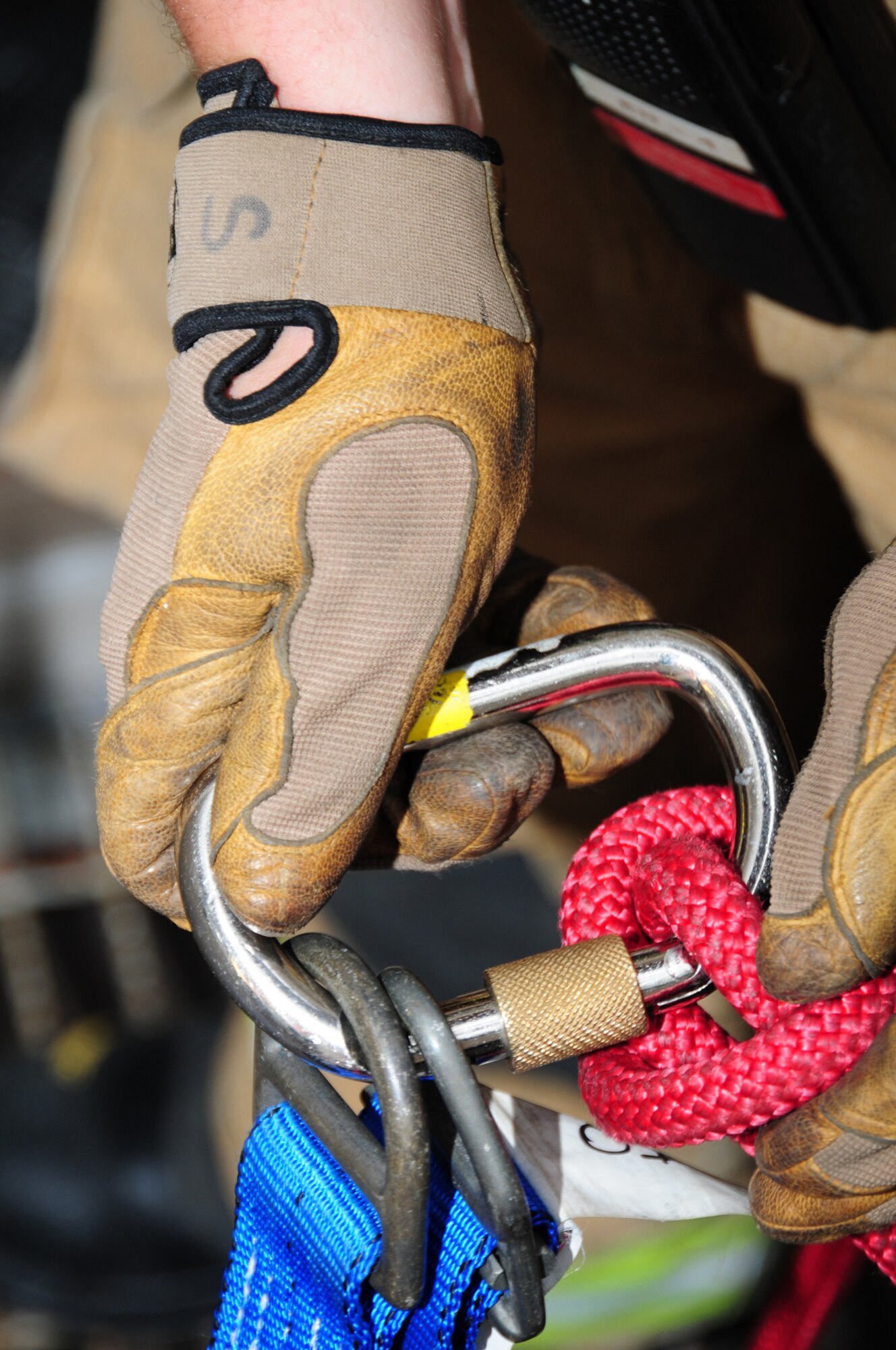 Staff Sgt. Justin Andreas, 100th Civil Engineer Squadron Fire Department firefighter from White Oak, Texas, rigs the belay line used as a back-up safety line when lowering a simulated casualty down a ladder vertically from the roof of building 809 July 2, 2013, on RAF Mildenhall, England. Firefighters perform confined-space-rescue training two or three times per year to ensure all personnel are fully qualified to rescue someone trapped in a confined space. (U.S. Air Force photo by Karen Abeyasekere/Released)