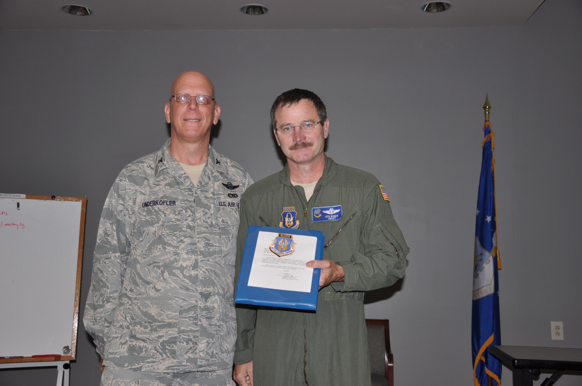 Col. Michael J. Underkofler, 514th Air Mobility Wing commander, gives the Air Force Command Individual Mishap-Free Flying-Hour Milestone award to Senior Master Sgt. Kenneth J. Buber, 514th Operations Support Squadron, for achieving 10,000 mishap-free flying hours and for his commitment to aviation safety during a civilian commander’s call held here July 2.