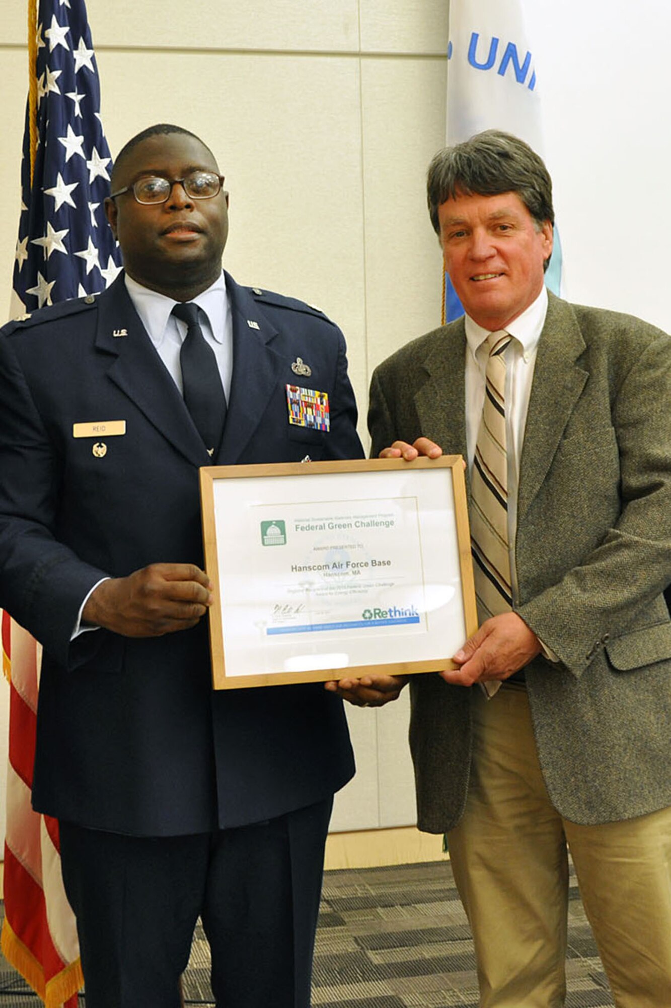 BOSTON -- Lt. Col. Romero Reid and Donald Morris accept the 2013 Federal Green Challenge Award for energy efficiency at a ceremony June 27. Hanscom achieved a 47 percent reduction in fuel oil usage by implementing a number of efficiency projects. A dual fueled Central Heat Plant shifted some of the fuel usage from oil to cleaner burning natural gas. Energy efficiency was also enhanced by insulating boiler steam and condensate lines and upgrading boilers to reuse waste heat. (Courtesy photo)