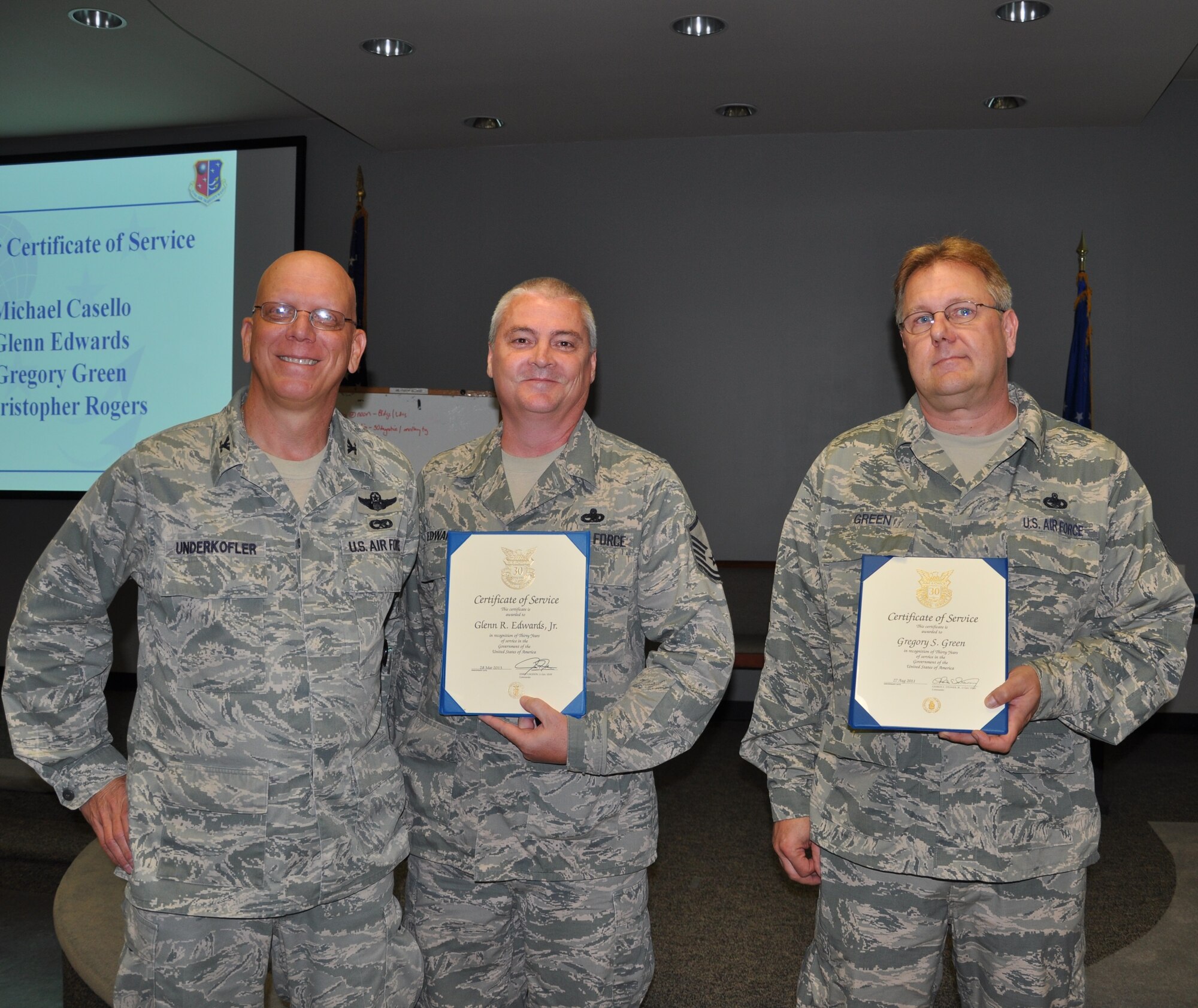 Master Sgt. Glenn Edwards, 514th Maintenance Squadron, and Master Sgt. Gregory Green, 514th Maintenance Operations Flight, stand with Col. Michael J. Underkofler, 514th Air Mobility Wing commander, upon receiving the 30 Year Certificate of Service award at a civilian commander’s call held here July 2. (U.S. Air Force photo by Tech. Sgt. Jonathan E. White)