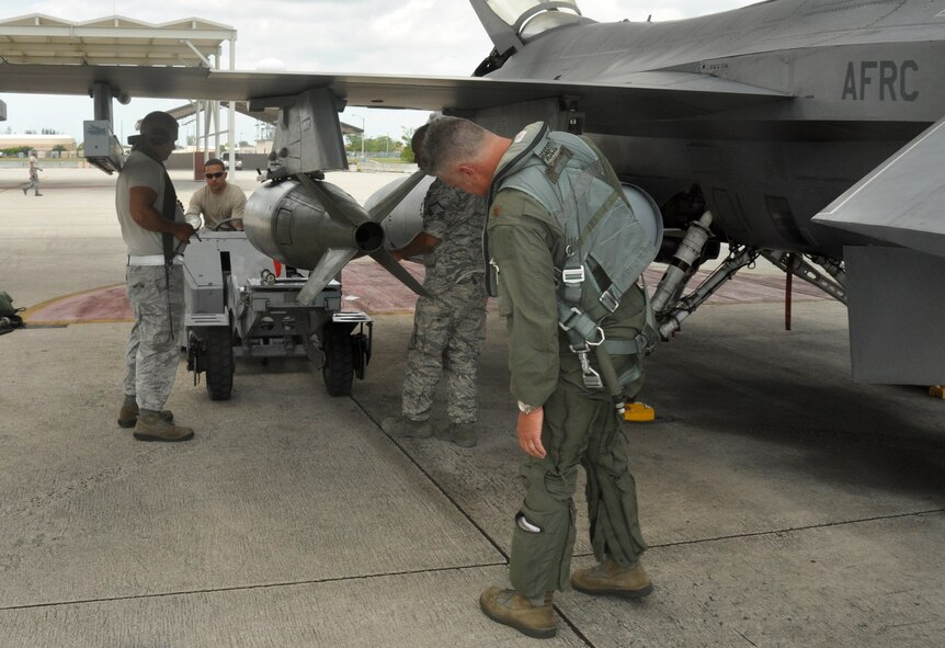 Maj. Robin Lytle, 93rd Fighter Squadron F-16 pilot and chief of scheduling, observes weapons loaders Master Sgt. Carlos Arias, 482nd Aircraft Maintenance Squadron, and Tech. Sgts. Ricardo Bachelor and Jonathan Edwards, both of the 495th Fighter Group, Detachment 93, as they load a bomb onto an F-16 at Homestead Air Reserve Base, Fla., May 17. Lytle began his career as a weapons loader at Bergstrom Air Force Base, Texas, in 1989. (U.S. Air Force photo/Senior Airman Jaimi Upthegrove)