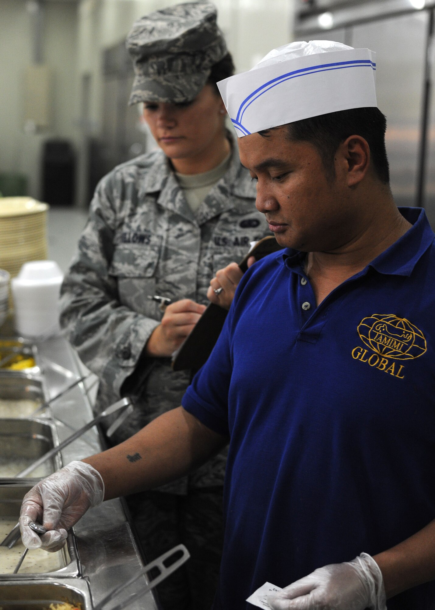 Padam Pun and Senior Airman Sarah Fellows monitor the food temperatures on the service line in the Independence Hall Dining Facility at the 379th Air Expeditionary Wing in Southwest Asia, July 10, 2013. Padam is an Independence Hall server and Fellows is a 379th Expeditionary Force Support Squadron food service journeyman deployed from Westover Air Reserve Base, Mass. (U.S. Air Force photo/Senior Airman Bahja J. Jones) 