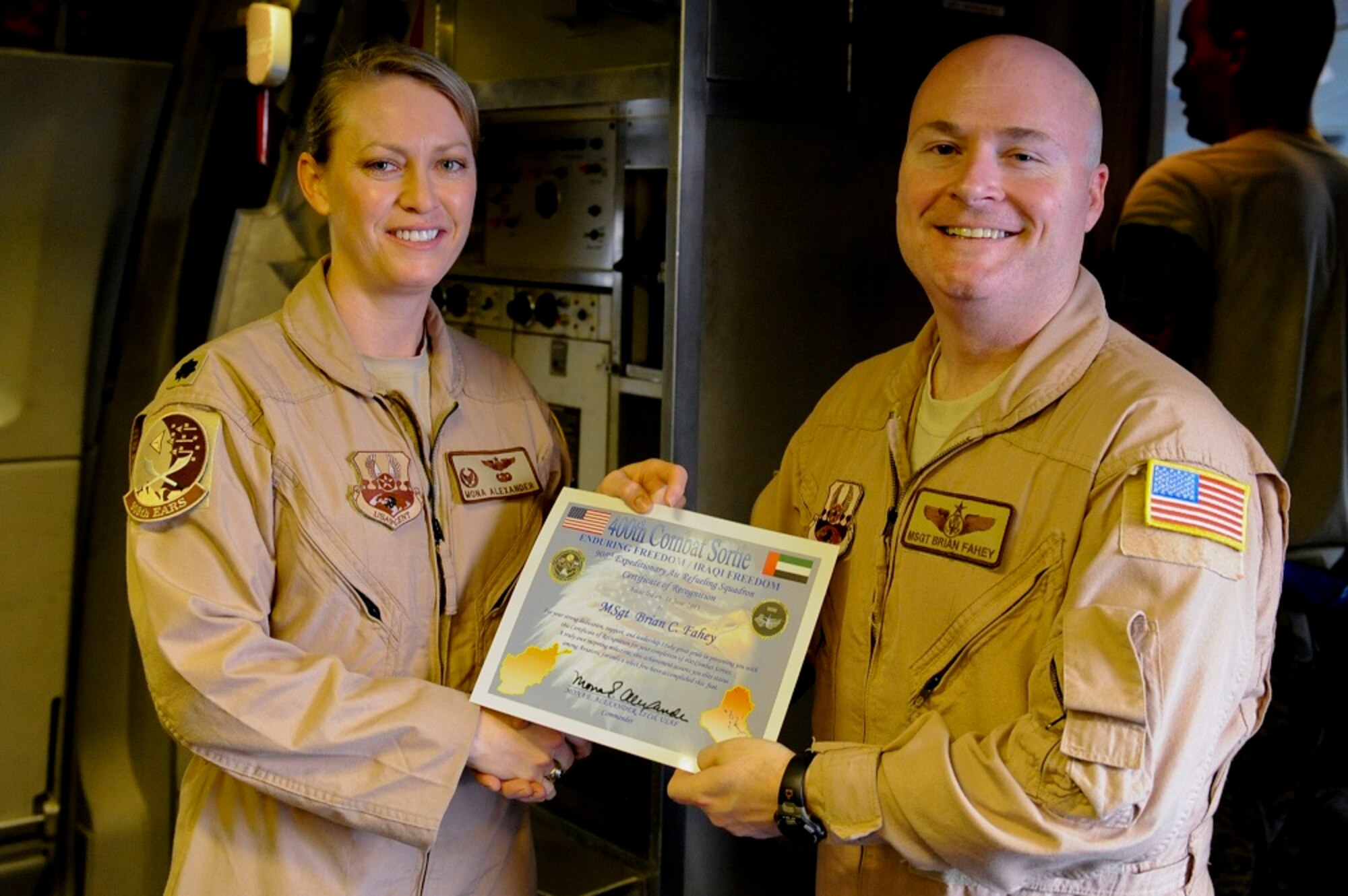 Lt. Col. Mona Alexander, 908th Expeditionary Air Refueling Squadron commander, presents Master Sgt. Brian Fahey, 908th EARS flight engineer, with a certificate signifying that Fahey had reached 400 combat sorties at an undisclosed location in Southwest Asia, June 14, 2013. Fahey accomplished this milestone with 255 missions flown on a KC-10 Extender and 145 missions on a MH-53 Pavelow in support of various operations around the area of responsibility. Alexander is stationed here and is a native of Sun City, Kansas, Fahey hails from Lakewood, N.J., and is deployed from Joint Base McGuire-Dix-Lakehurst, N.J. (U.S. Air Force photo by Staff Sgt. Joshua J. Garcia)