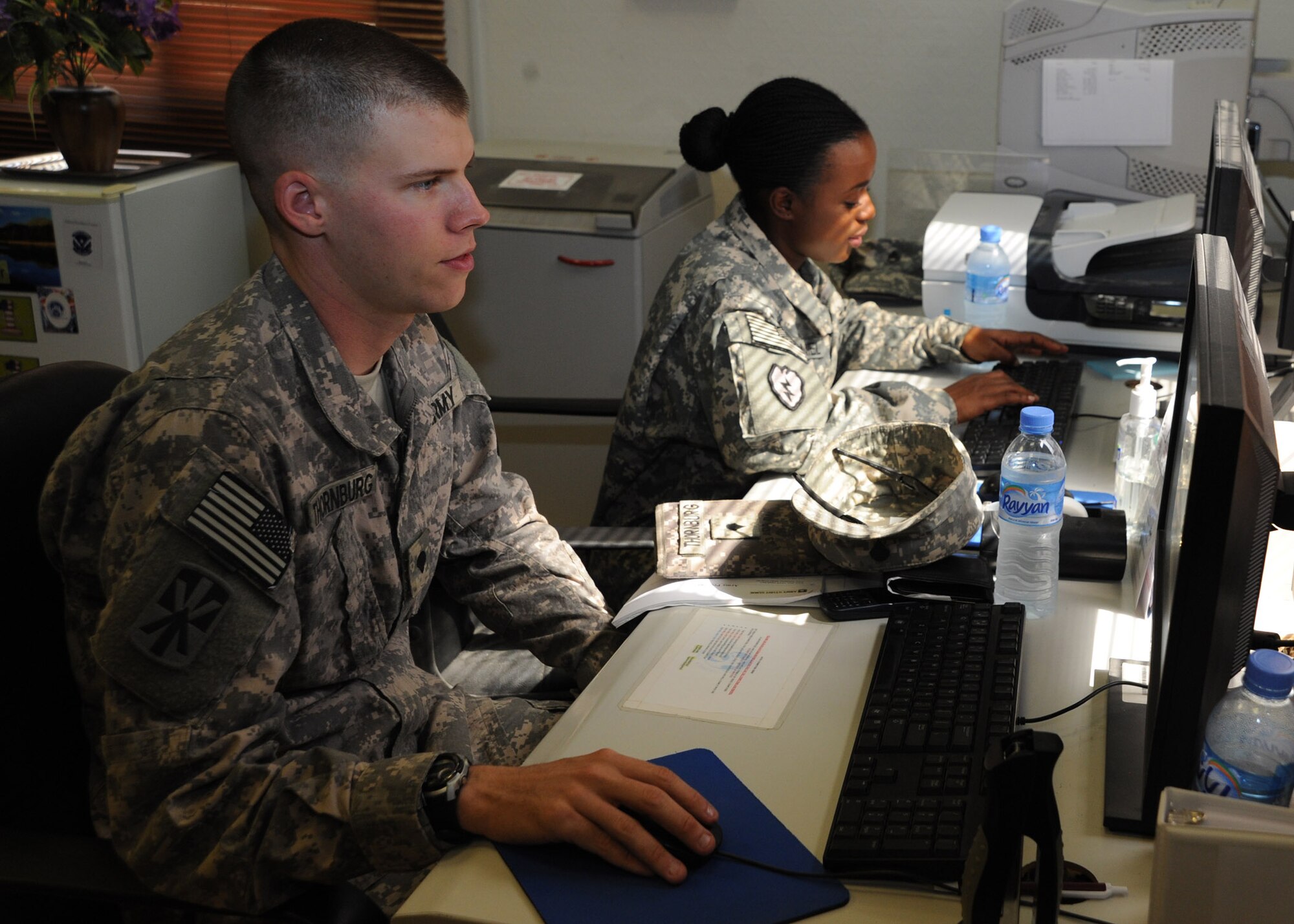 Army Spc. Robert Thornburg and Army Staff Sgt. Clarenda McDaniel use the morale computers located in the Airmen and Family Readiness Center at the 379th Air Expeditionary Wing in Southwest Asia, July 9, 2013. The A&FRC not only provides services to Airmen, but caters to all service members, civilian and contractors assigned to the 379th AEW. Thornburg and McDaniel are Task Force Cobra 1-43 Air Defense Artillery Battalion communications relay operators deployed from Fort Bliss, Texas. (U.S. Air Force photo/Senior Airman Bahja J. Jones) 