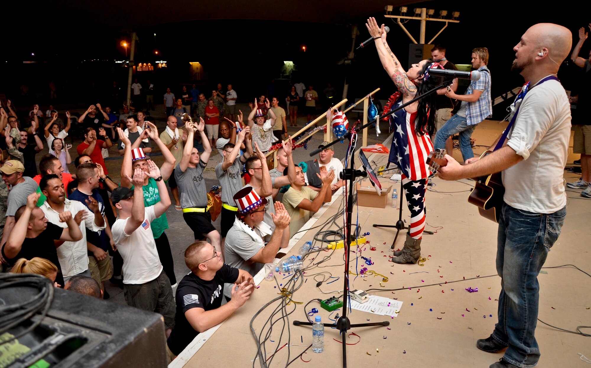 Grand Slam Wing service members rock out with events band, The Ringers, during the July Fourth celebration at the 379th Air Expeditionary Wing in Southwest Asia, July 4, 2013. The Ringers are a wedding and event band on tour from Minneapolis, Minn., and are back by popular request. After the first few songs, 379th AEW service members packed the stage, participated in a dance-off, and hung on every note until the band could play no more. (U.S. Air Force photo/Senior Airman Benjamin Stratton)
