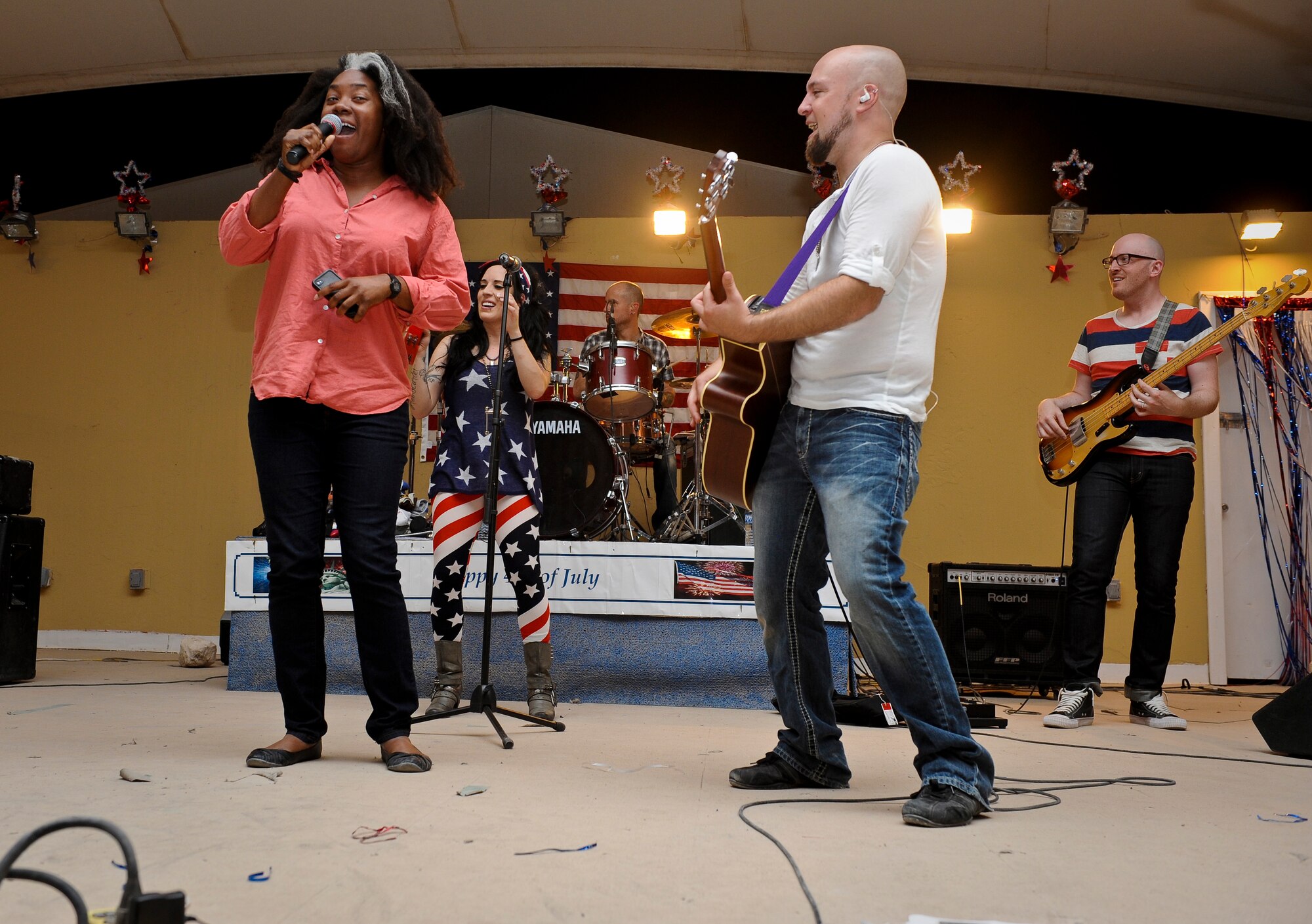The wing?s talent show winner, Jessica Tucker, performs with visiting event band, The Ringers, during the July Fourth celebration at the 379th Air Expeditionary Wing in Southwest Asia, July 4, 2013. The Ringers are a wedding and event band on tour from Minneapolis, Minn., and are back by popular request. Tucker is a 379th Expeditionary Contracting Squadron contract administrator. (U.S. Air Force photo/Senior Airman Benjamin Stratton)