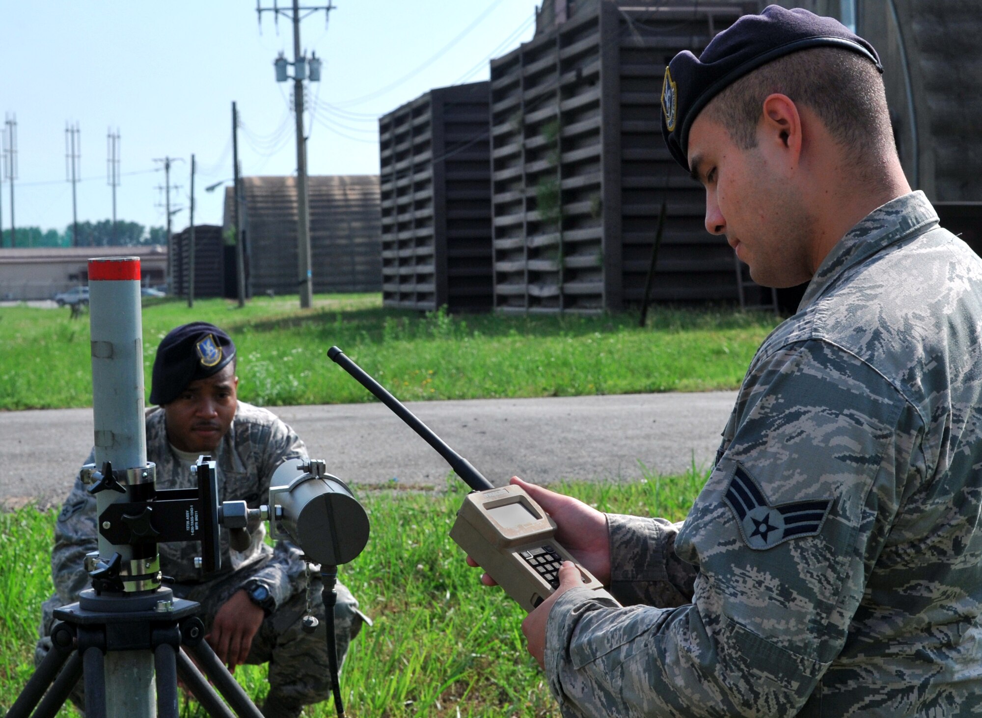 Senior Airman Eric Salazar checks readings on a handheld monitor while Airman 1st Class Taali Ruffin blocks the alignment of the transmitter to the receiver of a passive infrared sensor during a regular maintenance inspection on Osan Air Base, Republic of Korea, June 27, 2013. Both Salazar and Ruffin are tactical automated security system administrators with the 51st Security Forces Squadron. (U.S. Air Force photo/Senior Airman Kristina Overton)