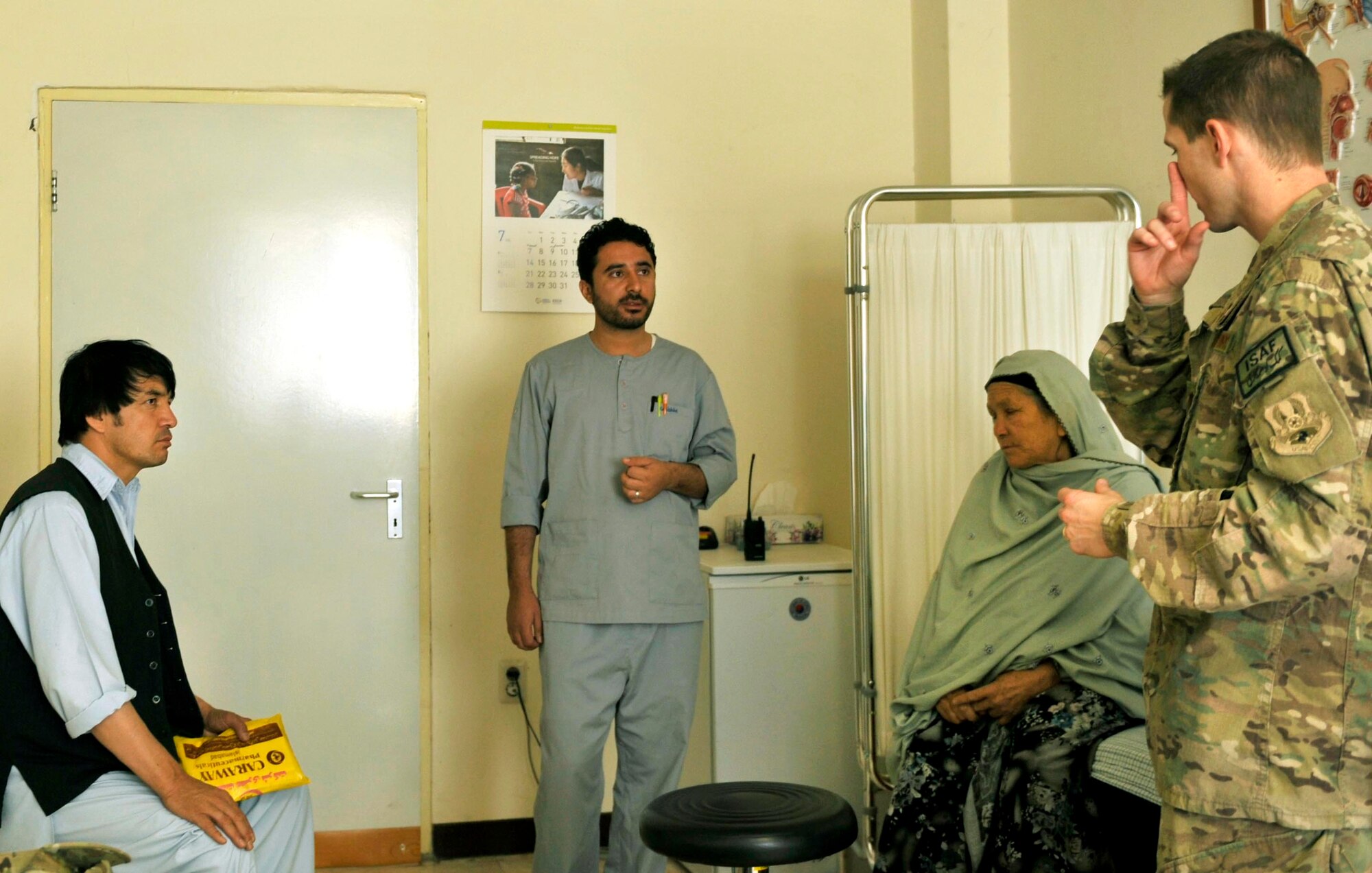 Maj. Marcus Neuffer, 455th Expeditionary Medical Group ophthalmologist, informs an interpreter and Afghan patient about her eye condition at the Korean Hospital on Bagram Airfield, Afghanistan, July 10. Neuffer and his technician Airman 1st Class Chellbie Gonzales, volunteer their services once a week at the Korean Hospital, one of two hospitals that treat walk-in, local-national patients. Both Maj Neuffer and A1C Gonzales are deployed from Keesler Air Force Base, Miss.  (U.S. Air Force photo/ Staff Sgt. Stephenie Wade)


