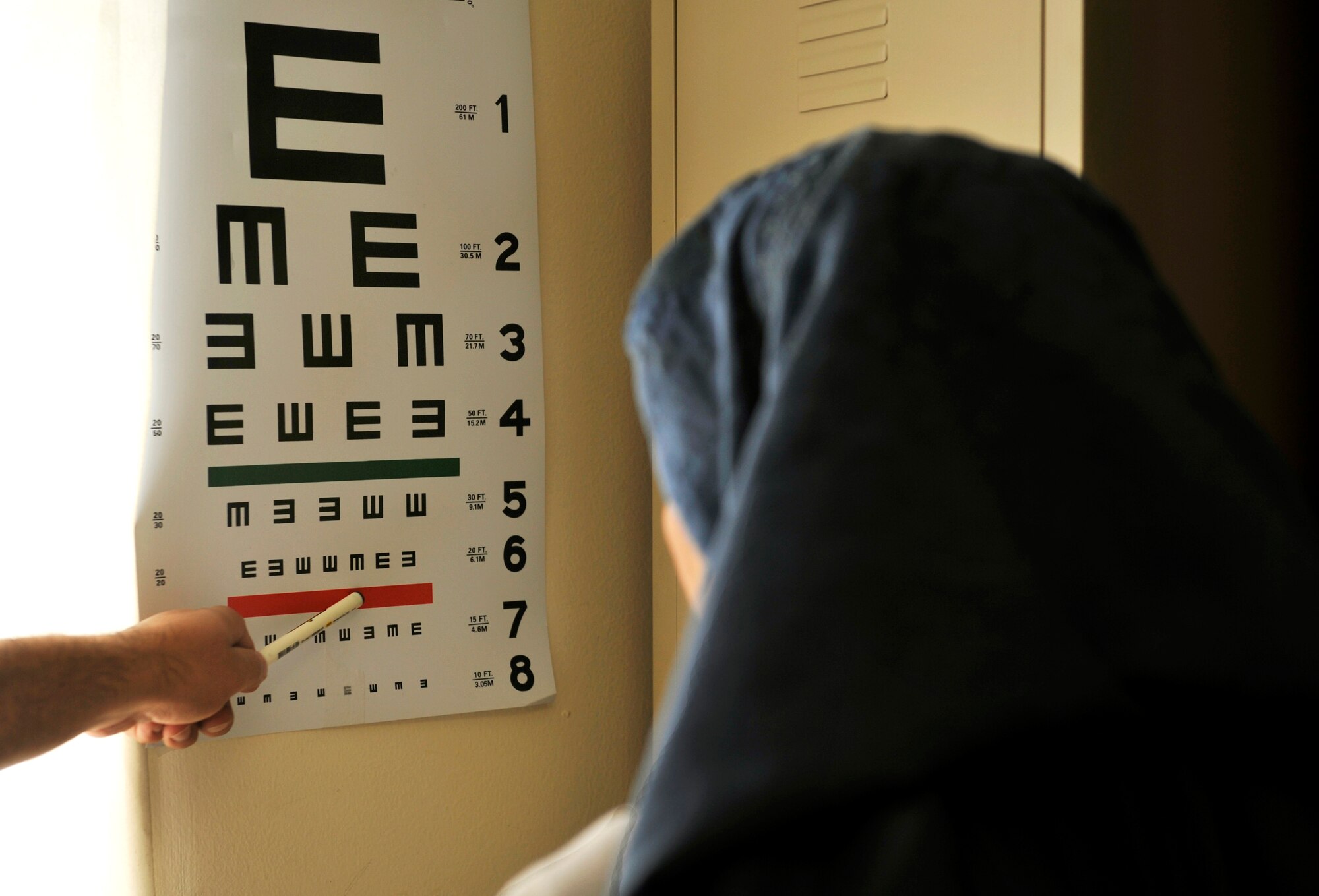 Maj. Marcus Neuffer, 455th Expeditionary Medical Group ophthalmologist administers an eye exam the Korean hospital on Bagram Airfield, Afghanistan, July 10. Neuffer and his technician Airman 1st Class Chellbie Gonzales, volunteer their services once a week at the Korean hospital, one of two hospitals here that treat walk-in, local-national patients. They are both deployed from Keesler Air Force Base, Miss. (U.S. Air Force photo/ Staff Sgt. Stephenie Wade)