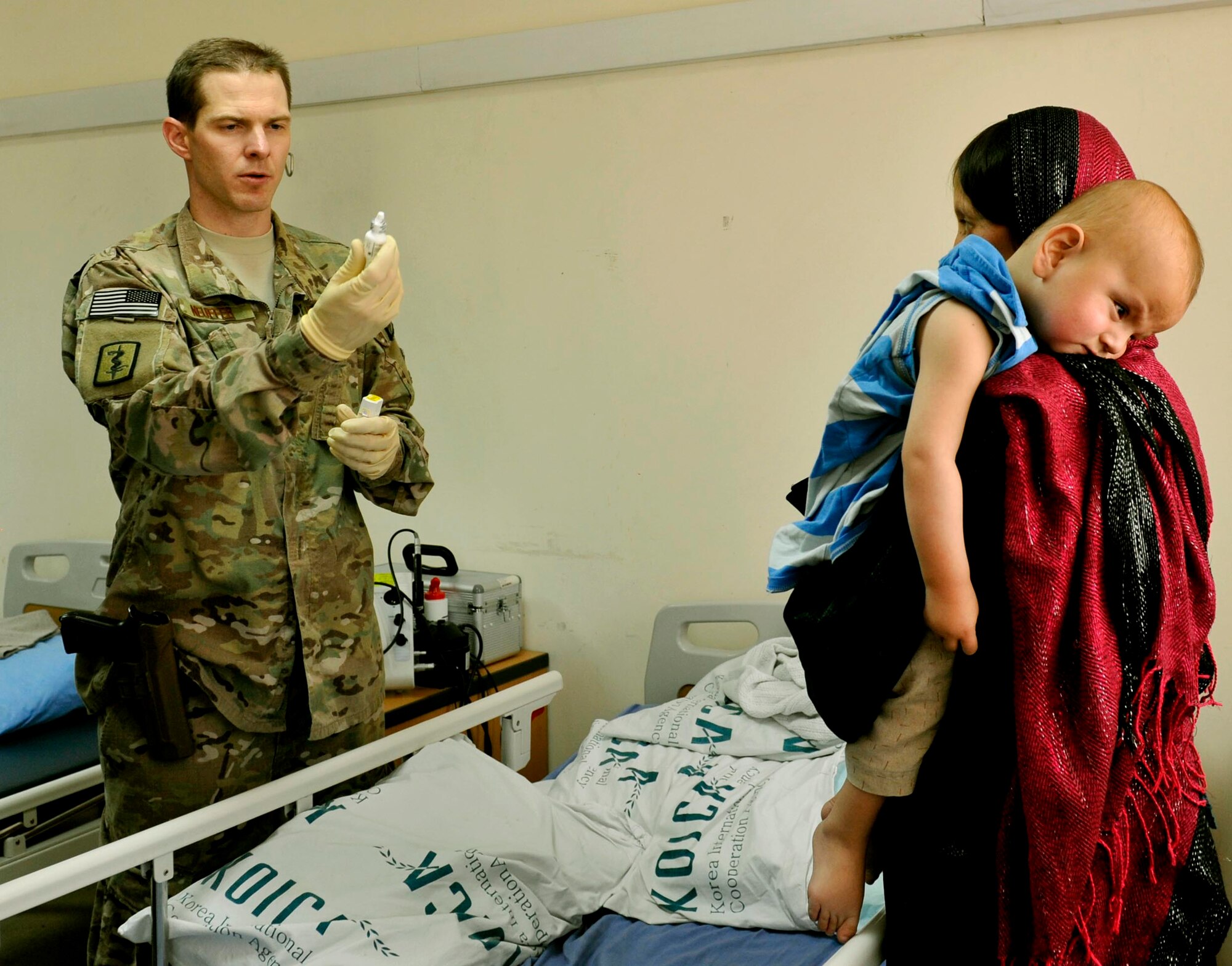 Maj. Marcus Neuffer, 455th Expeditionary Medical Group ophthalmologist explains application directions for medicine to a 12-month boy’s mother in the Korean hospital on Bagram Airfield, Afghanistan, July 7. The boy was diagnosed with cataracts among other conditions.  Neuffer is currently the only doctor on Bagram who is qualified to operate on eyes. If a local patient comes in to one of the humanitarian hospitals, the Korean or Egyptian hospital, and is need of an eye surgery, they are brought to the American hospital. According to Nueffer, a child’s eye sight stops developing at about eight. If corrective surgery can be performed before then, with glasses, children should be able to regain enough vision to perform daily tasks. He is deployed from Keesler Air Force Base, Miss. (U.S. Air Force photo/ Staff Sgt. Stephenie Wade)