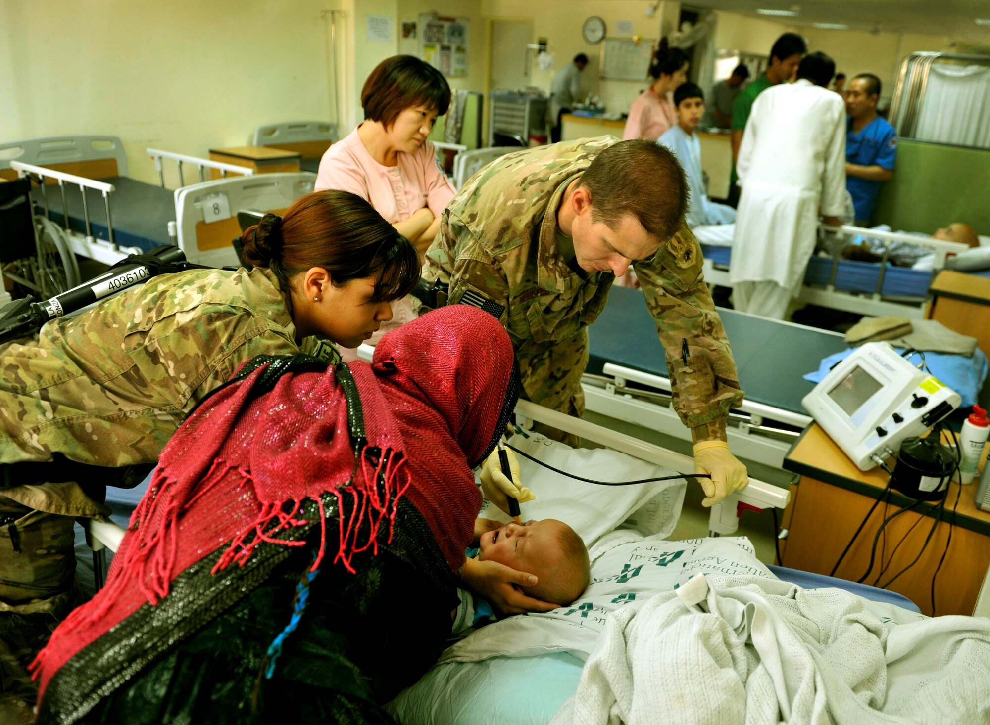 Maj. Marcus Neuffer, 455th Expeditionary Medical Group ophthalmologist, and his technician, Airman 1st Class Chellbie Gonzales, conduct an ultrasound on the left eye of a 12-month boy in the Korean hospital on Bagram Airfield, Afghanistan, July 7. Neuffer is currently the only doctor on Bagram who is qualified to operate on eyes. If a local patient comes in to one of the humanitarian hospitals, the Korean or Egyptian hospital, and is need of an eye surgery, they are brought to the American hospital. According to Nueffer, a child’s eye sight stops developing at about eight. If corrective surgery can be performed before then, with glasses, children should be able to regain enough vision to perform daily tasks. Both Maj Neuffer and A1C Gonzales are deployed from Keesler Air Force Base, Miss.  (U.S. Air Force photo/ Staff Sgt. Stephenie Wade)