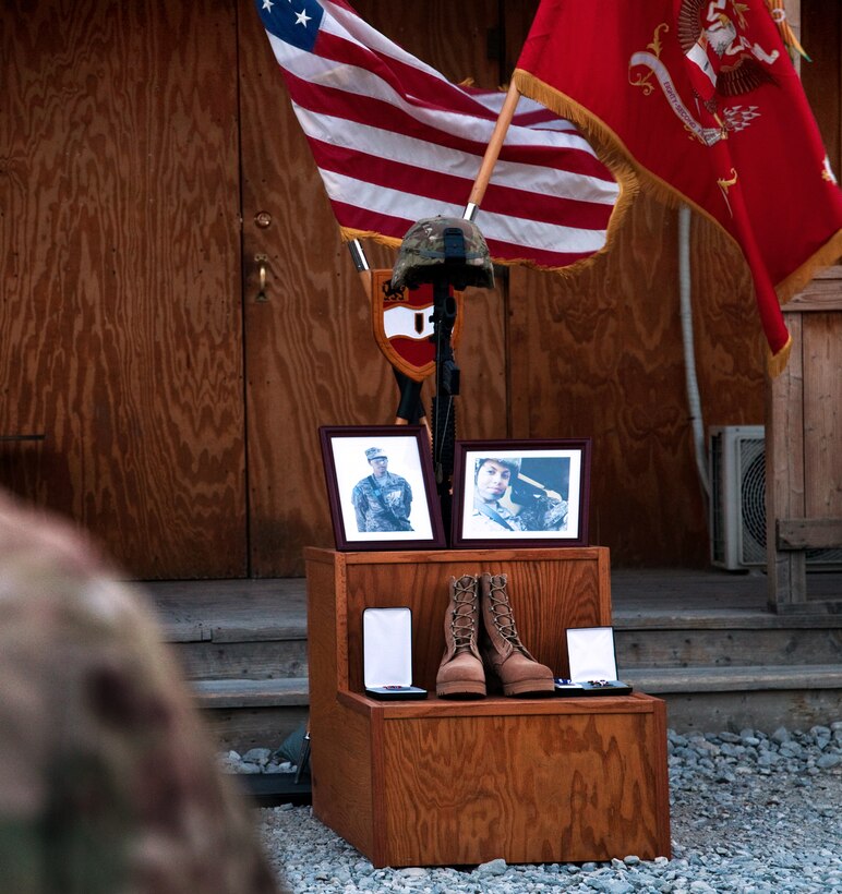 A display of framed pictures and a battlefield cross serve as a focus during a memorial ceremony for U.S. Army Spc. Hilda I. Clayton on Forward Operating Base Gamberi, Afghanistan, July 8, 2013.