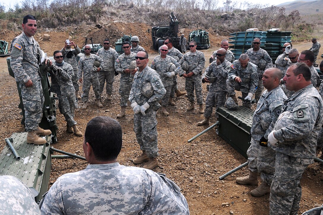 A soldier conducts a mission debrief after after his unit learned how to assemble a medium girder bridge during annual training on Camp Santiago Joint Maneuver Training Center in Salinas, Puerto Rico, July 9, 2013.