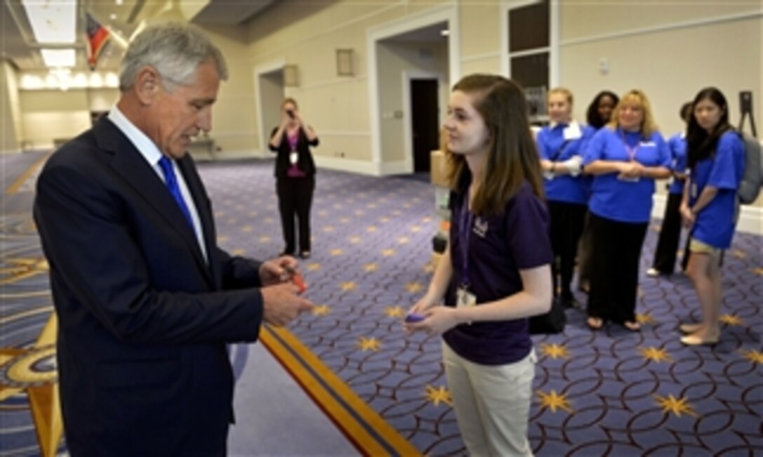 Rebekah Greer, right, presents Secretary of Defense Chuck Hagel, left, with a bracelet from her school after he delivered remarks at the Military Child Education Coalition Training Seminar in the Gaylord National Hotel & Convention Center at National Harbor, Md., on July 9, 2013.  Greer is a senior at Steilacoom Historical School District No. 1, of Steilacoom, Wash.   