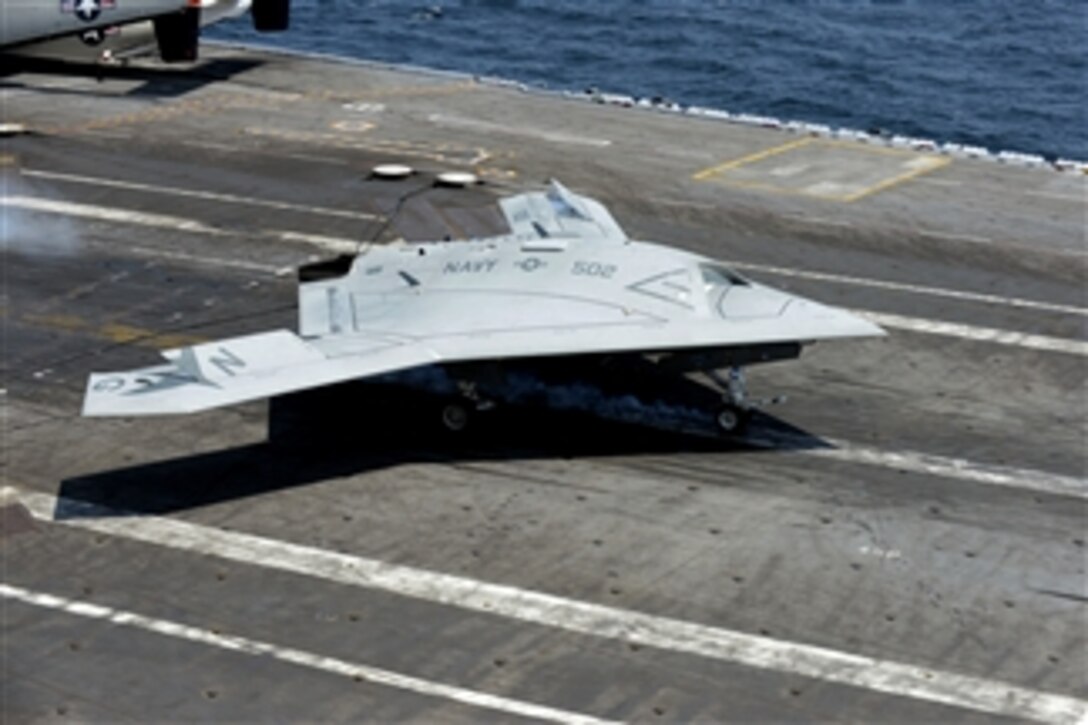 A U.S. Navy X-47B Unmanned Combat Air System makes an arrested landing aboard the aircraft carrier USS George H.W. Bush (CVN 77) as the ship conducts flight operations in the Atlantic Ocean off the coast of Virginia on July 10, 2013.  The successful landing marks the first time a tail-less, unmanned autonomous aircraft landed on a modern aircraft carrier.  