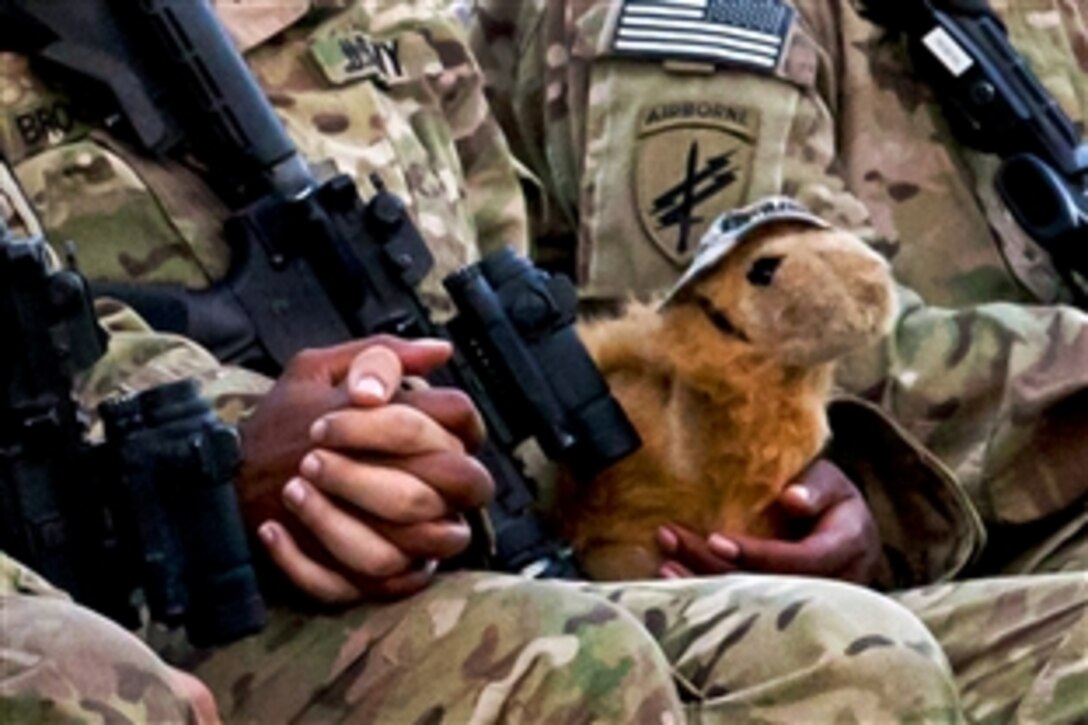 U.S. soldiers hold hands during a memorial ceremony for U.S. Army Spc. Hilda I. Clayton on Forward Operating Base Gamberi, Afghanistan, July 8, 2013.  Clayton, a combat cameraman, was assigned to the 1st Cavalry Division's 4th Brigade Combat Team. She died while photographing Afghan soldiers July 2 as they conducted a live-fire training exercise in which a mortar weapon system failed, causing an explosion. Four Afghan soldiers also died from the incident.