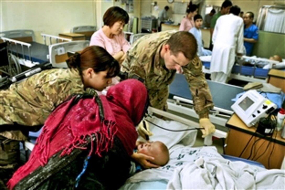 U.S. Air Force Maj. Marcus Neuffer and U.S. Air Force Airman 1st Class Chellbie Gonzales conduct an ultrasound on the left eye of a 12-month-old boy in the Korean Hospital on Bagram Airfield, Afghanistan, July 7, 2013. Neuffer, a ophthalmologist, and Gonzales, a technician, are assigned to the 455th Expeditionary Medical Group.
