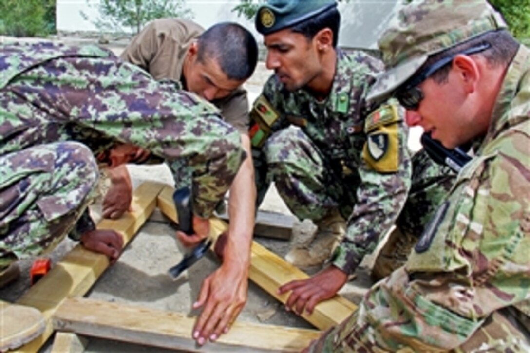 U.S. Army Spc. Taylor Neitman, right, observes as an Afghan soldier hammers a nail on a truss on Forward Operating Base Thunder in Afghanistan’s Paktya province, July 2, 2013. Neitman, a carpentry and masonry specialist, is assigned to the 859th Engineer Company, Security Advise and Assist Team 4.