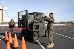 129th Aerial Port Flight personnel perform safety training at Moffett Federal Airfield, Jan. 4. Senior Airman Razvan Sonea operates a forklift while Staff Sgt. Felipe Mancera demonstrates safety procedures. The 129th Logistics Readiness Squadron's Aerial Port Flight stood up Nov. 1, 2008. 129th Aerial Port personnel, also known as "Port Dogs," are specialized Airmen trained to manage in-transit passenger and cargo movements for state directed missions and AEF deployments, redeployments, and exercises.