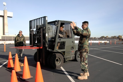 129th Aerial Port Flight personnel perform safety training at Moffett Federal Airfield, Jan. 4. Senior Airman Razvan Sonea operates a forklift while Staff Sgt. Felipe Mancera demonstrates safety procedures. The 129th Logistics Readiness Squadron's Aerial Port Flight stood up Nov. 1, 2008. 129th Aerial Port personnel, also known as "Port Dogs," are specialized Airmen trained to manage in-transit passenger and cargo movements for state directed missions and AEF deployments, redeployments, and exercises.