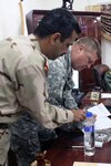 Staff Brig. Gen. Adel, the commander of the First Quick Reaction Force Brigade, Iraqi army, headquartered at Camp Ali, and U.S. Army Col. Ronald Kapral, the commander of Camp Ramadi and the 81st Brigade Combat Team, Washington Army National Guard, sign a memorandum of agreement turning Camp Ramadi over to the Iraqi government Jan. 20 at Camp Ali, Iraq. The signing over of Camp Ramadi is a step toward coalition forces pulling out and handing complete responsibility and control back over to the Iraqis.