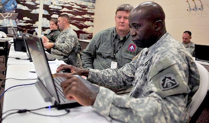 U.S. Army Master Sgt. Dale Lee talks with James Skidmore, Deputy J-3, both from Joint Task Force – 51, U.S. Army North, based out of Fort Sam Houston, Texas, to plan and execute Title X support to Hurricane Irene relief efforts Aug. 27 at Joint Base McGuire-Dix-Lakehurst, N.J., in anticipation of requests for assistance from the Federal Emergency Management Agency, which is the overall lead for the federal response effort for Hurricane Irene. Hurricane Irene made landfall Aug. 27 on the eastern coast of the United States and is expected to reach the JB MDL area early Sunday morning. 

