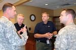 Col. Barrett Holmes (left) meets with Michael Byrne, Glen Sachtleben, and Capt. Chris Colbert, as the four prepared to board a UH-60 helicopter Aug. 28 to conduct an initial damage assessment of North Carolina. Holmes is the defense coordinating officer for U.S. Army North’s Region IV Defense Coordinating Element. Byrne is a federal coordinating officer, and Sachtleben, an operations officer, both with the Federal Emergency Management Agency. Colbert is the pilot of the helicopter from the 3rd Infantry Division’s Combat Aviation Brigade that conducted the flight mission in support of FEMA, which is the overall lead for the federal response effort for Hurricane Irene. 

