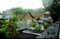 U.S. Air Force Senior Airman Joshua Garner, pavement and equipment operator from Joint Base Anacostia-Bolling Public Works, clean up tree branches that were knocked lose during heavy rains and winds brought from Hurricane Irene at JBAB, D.C., Aug. 27. (U.S. Air Force photo by Staff Sgt. Brittany E. Jones) (Released)