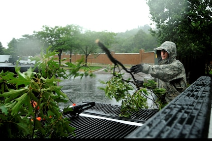 U.S. Air Force Senior Airman Joshua Garner, pavement and equipment operator from Joint Base Anacostia-Bolling Public Works, clean up tree branches that were knocked lose during heavy rains and winds brought from Hurricane Irene at JBAB, D.C., Aug. 27. (U.S. Air Force photo by Staff Sgt. Brittany E. Jones) (Released)