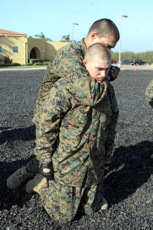 Recruits of Company L, 3rd Recruit Training Battalion, perform a rear-choke during an examination aboard Marine Corps Recruit Depot San Diego June 26. An examination is administered to make sure recruits are knowledgeable of all MCMAP taught throughout recruit training.  