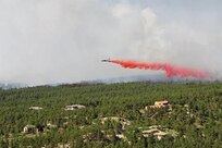 An aircraft releases a fire-retardant solution to help stop the spreading of fires at Black Forest, Colo., June 12, 2013 

