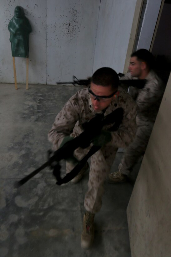 Petty Officer 3rd Class Christopher Green, a religious program specialist serving with Combat Logistics Regiment 15, and a native of San Francisco, clears a room with Petty Officer 3rd Class Jarrod Tesch, a religious program specialist serving with 1st Battalion, 4th Marine Regiment, and a native of Las Lunas, N.M., during the urban leaders course here, July 9, 2013. The weeklong course covers various urban warfare tactics including room clearing and military operations on urban terrain.
