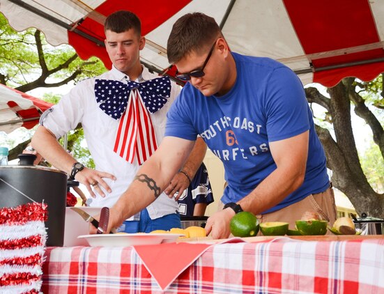 Pfc. Ben Murray, a Marine Air Ground Task Force planner with Marine Aircraft Group 24 (left), watches Lance Cpl. Ronnie Kuhn, a MAGTF planner with MAG-24 as he cuts an avocado during the Marine Aircraft Group 24 chili cook-off at Dewey Square, July 3, 2013. (U.S. Marine Corps photo by Kristen Wong)