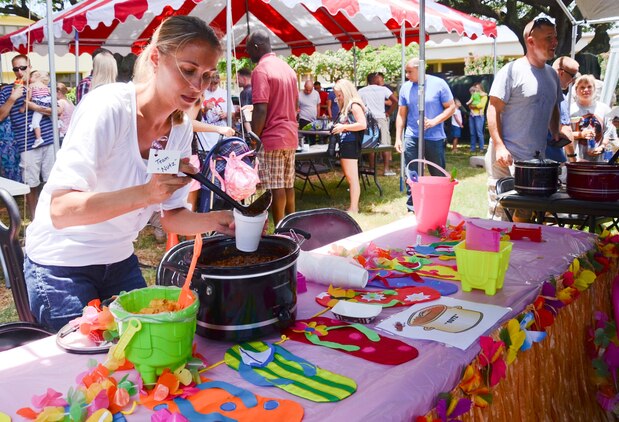 Kim Bignell, a member of the “Nutz” team, pours chili into a cup during the Marine Aircraft Group 24 chili cook-off at Dewey Square, July 3, 2013. (U.S. Marine Corps photo by Kristen Wong)