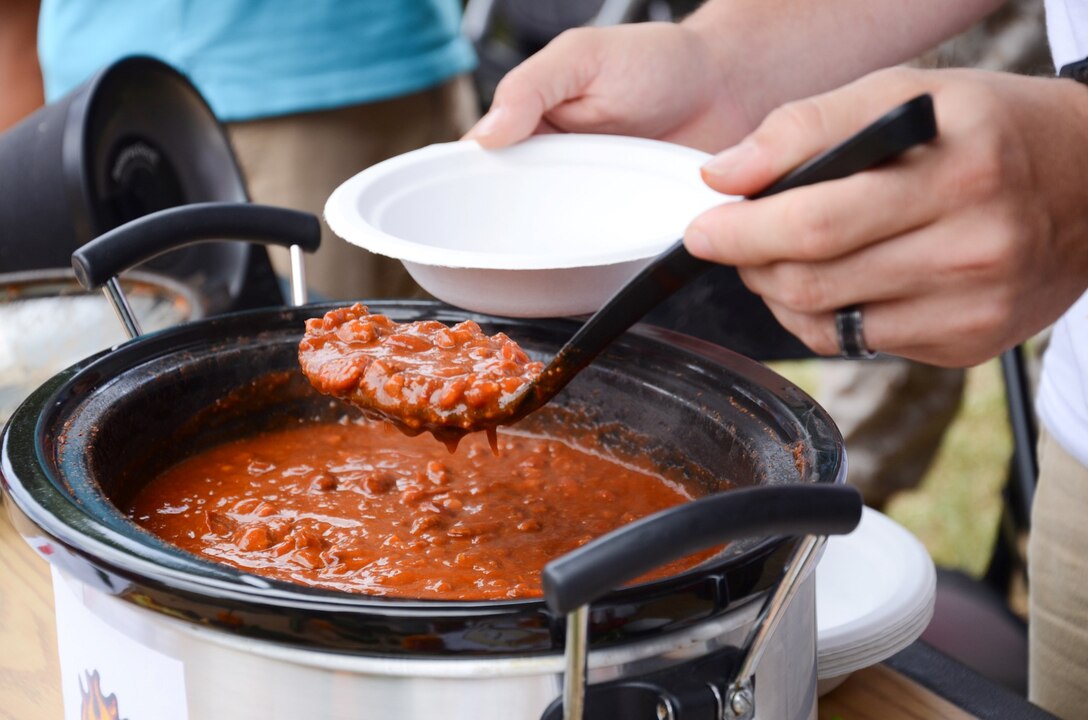 Sgt. David Revels, an avionics technician with Marine Light Attack Helicopter Squadron 367, serves chili during the Marine Aircraft Group 24 chili cook-off at Dewey Square, July 3, 2013. (U.S. Marine Corps photo by Kristen Wong)