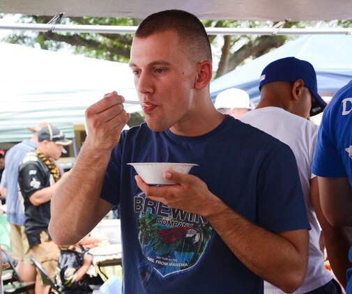 Lance Cpl. Patrick Bock, a maintenance management specialist with Marine Wing Support Detachment 24 samples chili made by Sgt. Michael Moody, heavy equipment mechanic, MWSD-24, during the Marine Aircraft Group 24 chili cook-off at Dewey Square, July 3, 2013. (U.S. Marine Corps photo by Kristen Wong)