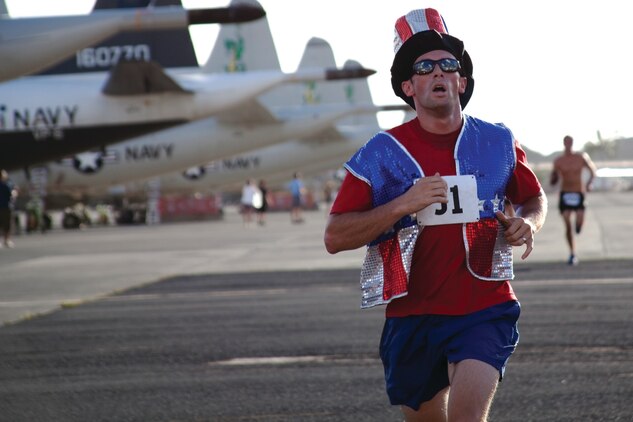 Carlos Martinez sprints to the finish line at Hangar 104 for the base's annual Runway Run 5k, July 4, 2013. The run is part of the 101 Days of Summer program. (U.S. Marine Corps photo by Lance Cpl. Janelle Y. Chapman)