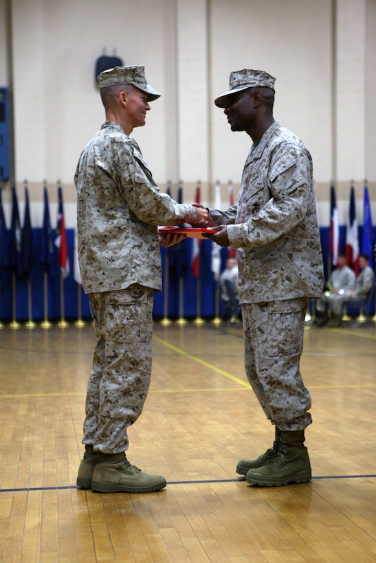CAMP GEIGER, N.C. - Col. Jeffrey T. Conner, School of Infantry-East commanding officer, shakes hands with and gives an award to Lt. Col. Stacey L. Taylor, School of Infantry-East Headquarters and Support Battalion outgoing commanding officer, during a change of command ceremony at the Camp Geiger Fitness Center aboard Camp Geiger, a satellite installation of Marine Corps Base Camp Lejeune, June 28. Taylor handed the reigns of the battalion to Lt. Col. Ricardo T. Player, School of Infantry-East Headquarters and Support Battalion oncoming commanding officer. Taylor and Player both attended Kappa Alpha Psi fraternity, following the footsteps of Capt. Fredrick C. Branch, the first African American Marine Corps commissioned officer. "It is my duty to provide the leadership so that H&S Battalion Marines are taken care of in order to accomplish their mission," said Player. "I'm humble, excited and motivated. It's truly an honor to lead this great battalion."