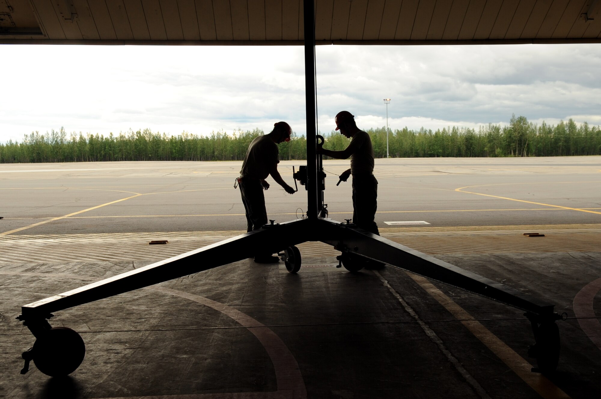 U.S Air Force Staff Sgt. David Dunning and Senior Airman Joseph Levin, 354th Aircraft Maintenance Squadron weapons load crew members, set up a cobra crane July 9, 2013, Eielson Air Force Base, Alaska.  As a safety measure, the crane must be operated by two people at all times due to its size.  (U.S. Air Force photo by Airman 1st Class Lauren-Taylor Levin/Released)