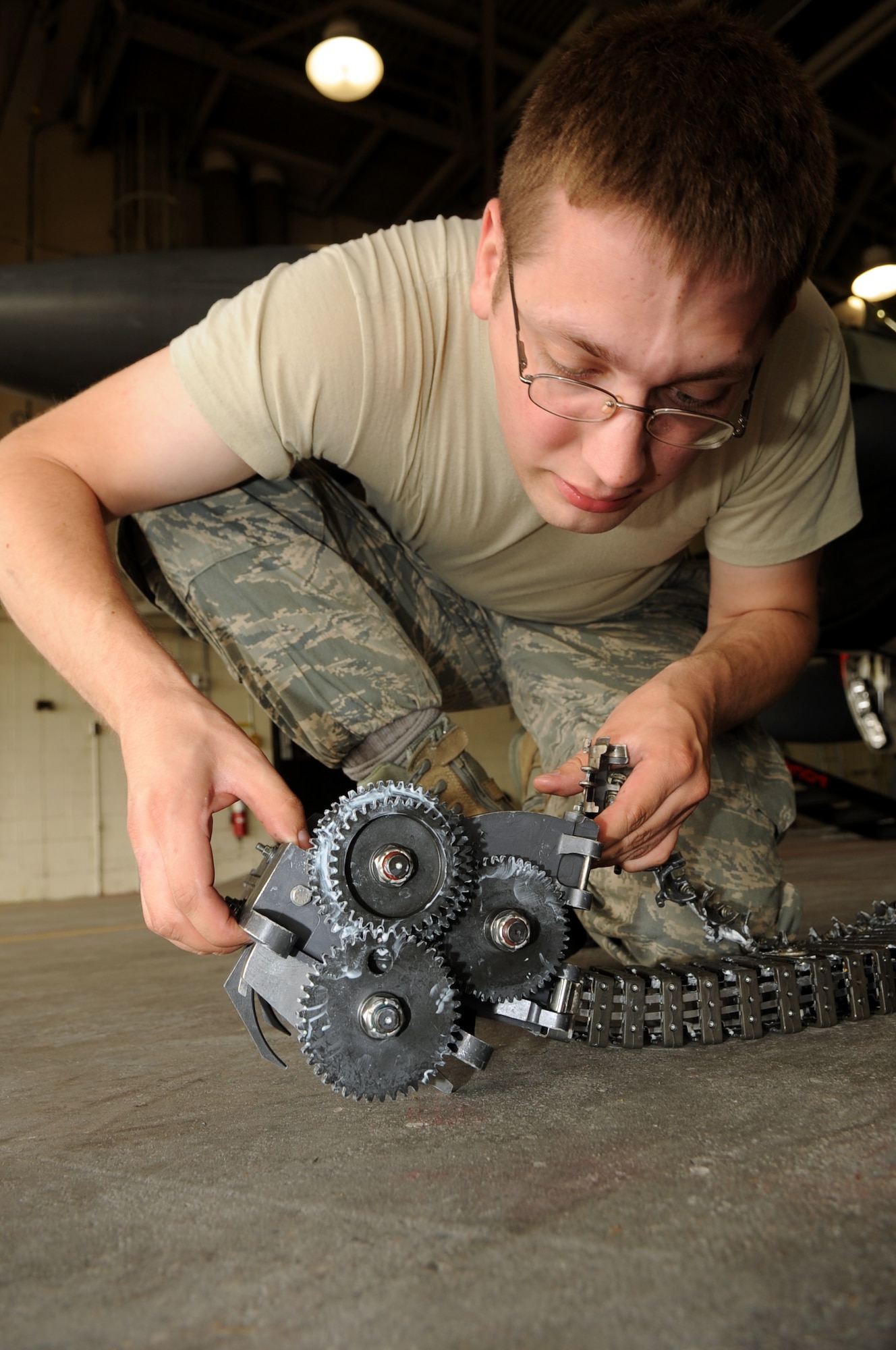 U.S Air Force Staff Sgt. David Dunning, 354th Aircraft Maintenance Squadron weapons load crew member, attaches the element shoot to an entrance and exit unit July 9, 2013, Eielson Air Force Base, Alaska. In order for the bullets to get to the drum they must go through the entrance and exit unit. (U.S. Air Force photo by Airman 1st Class Lauren-Taylor Levin/Released)